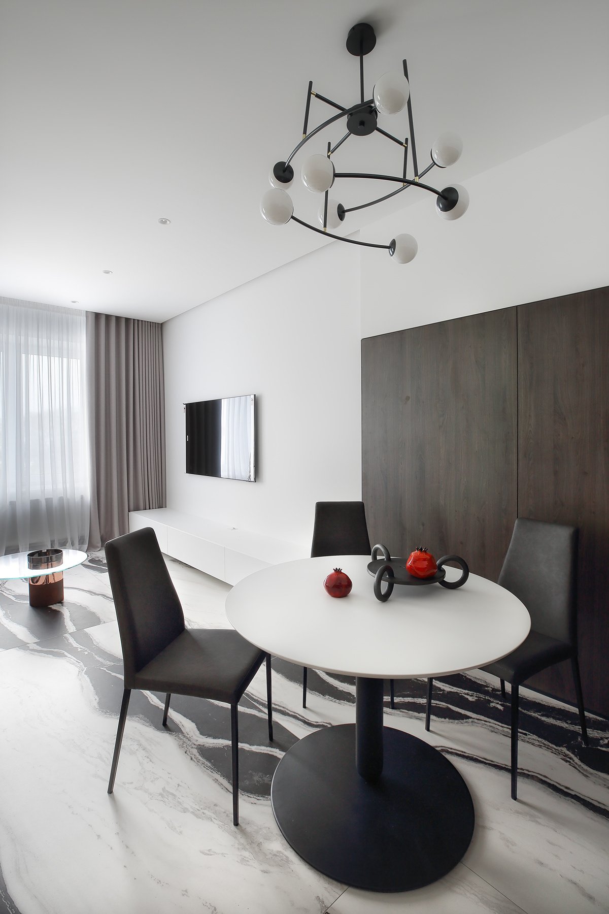 Dining nook with a round table and sculptural chandelier.