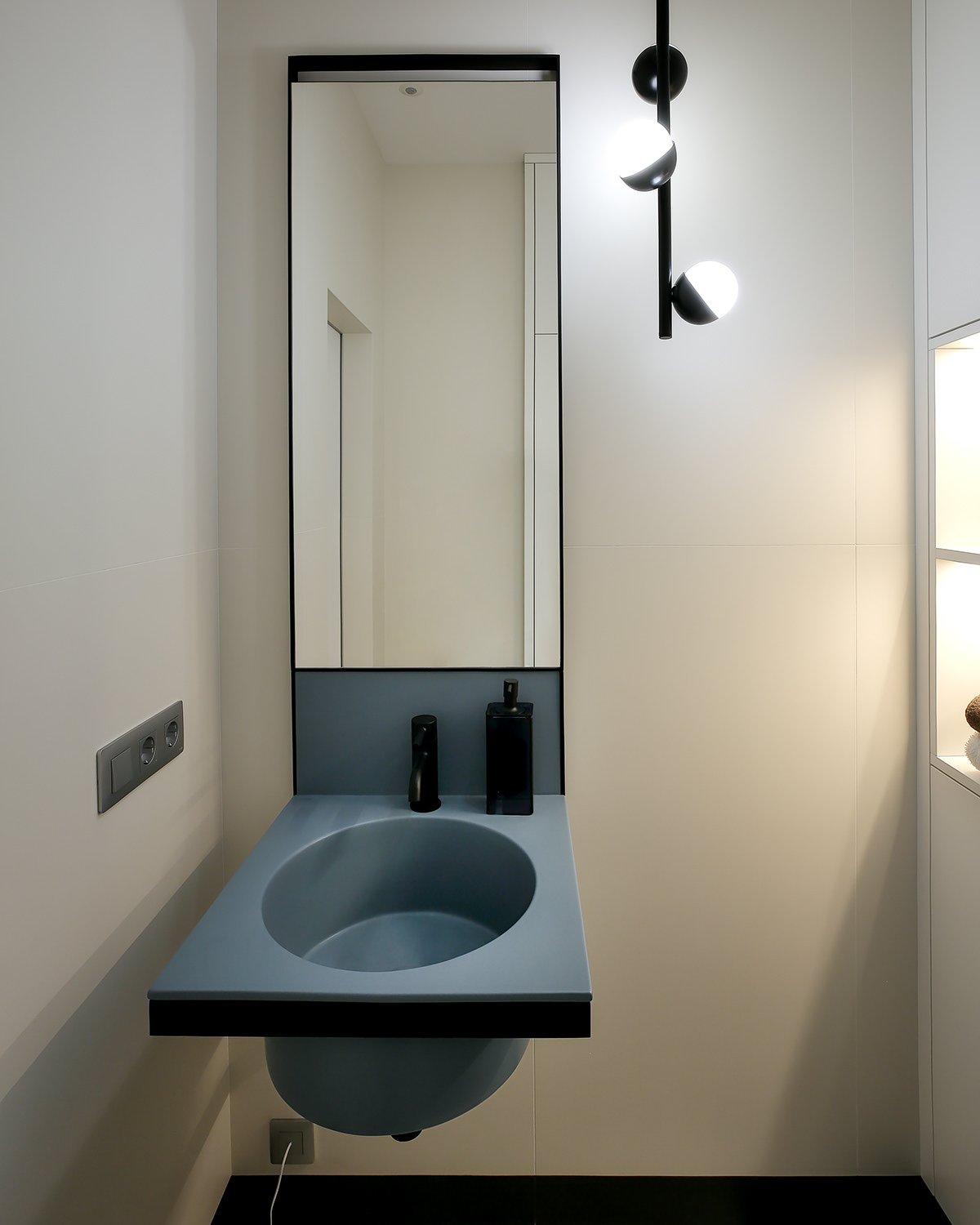 Small powder room with a round sink and mirror.