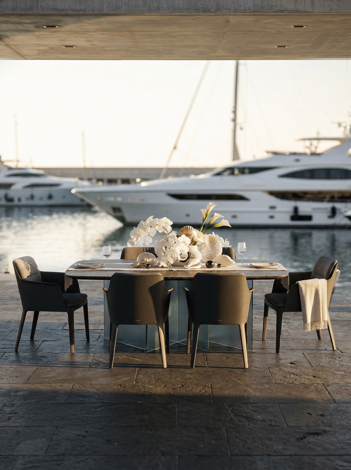 Outdoor dining terrace set for service, with yachts in the marina beyond.