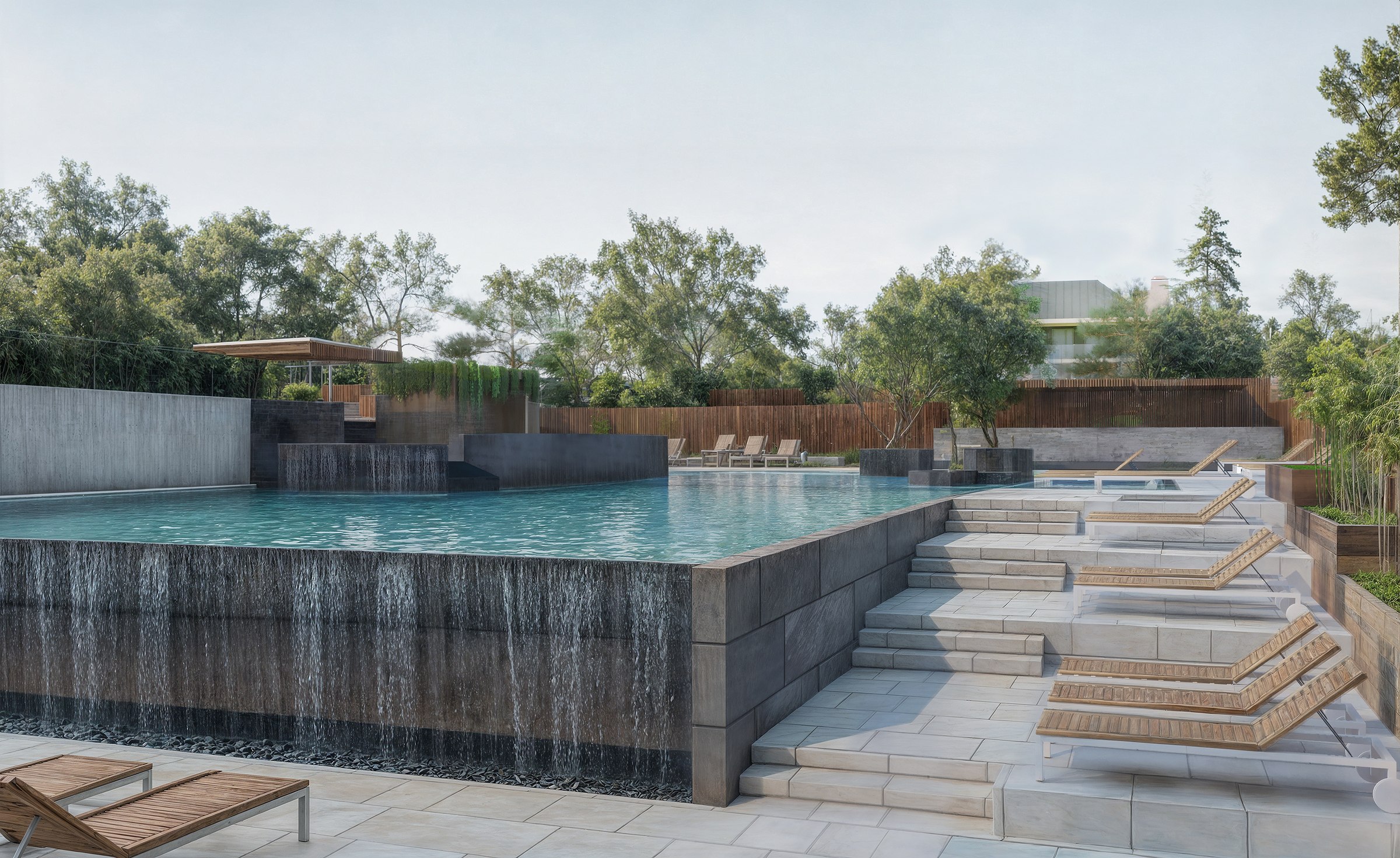Infinity-edge pool with a waterfall wall and wooden loungers.