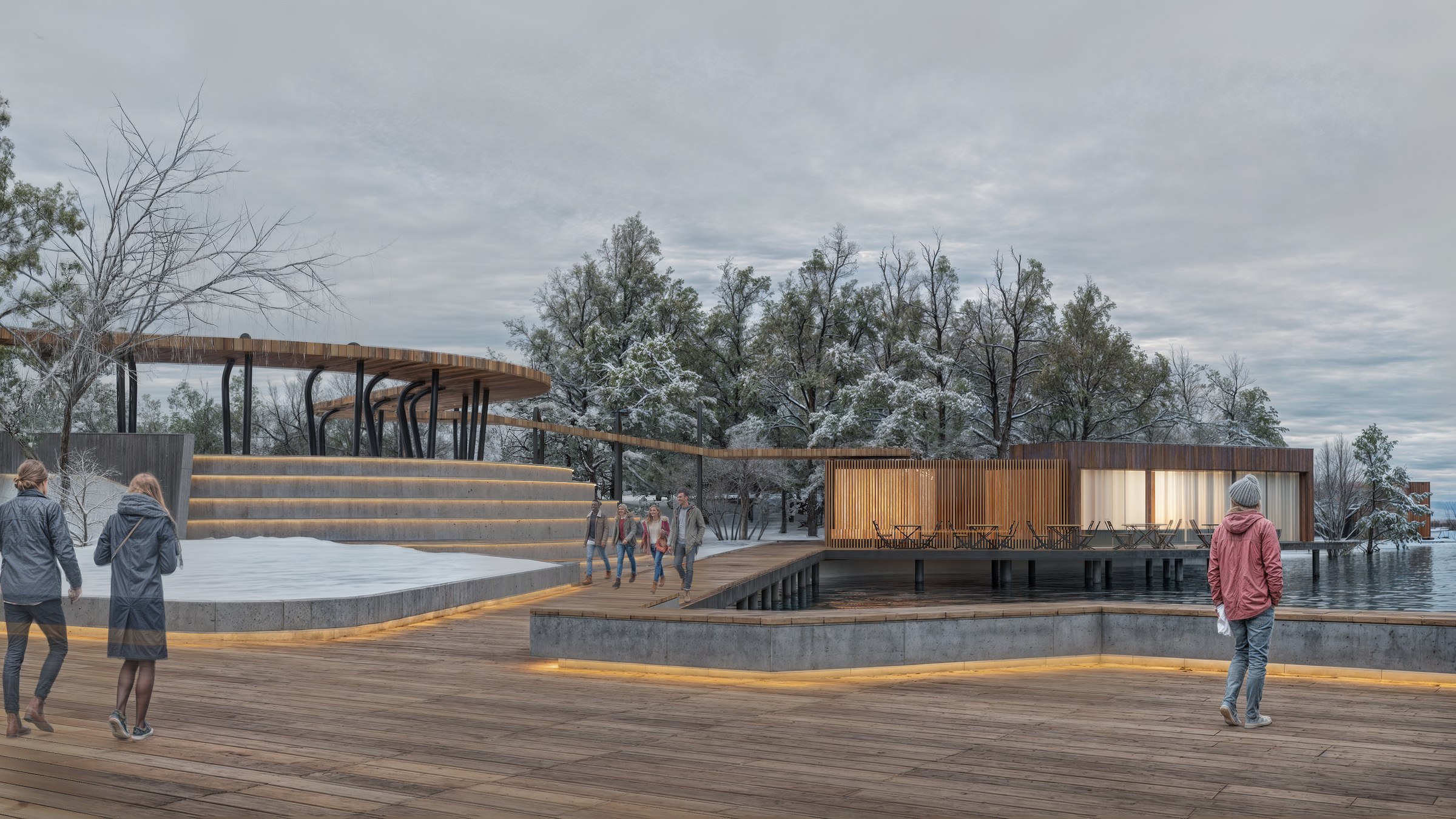 Winter view of the riverside promenade and amphitheater seating, with guests walking along the boardwalk.