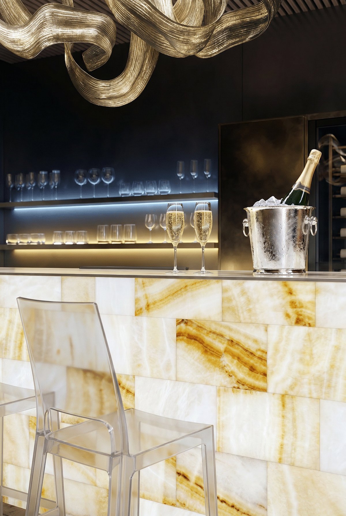 Bar counter detail with onyx surface, glassware and a champagne bucket.